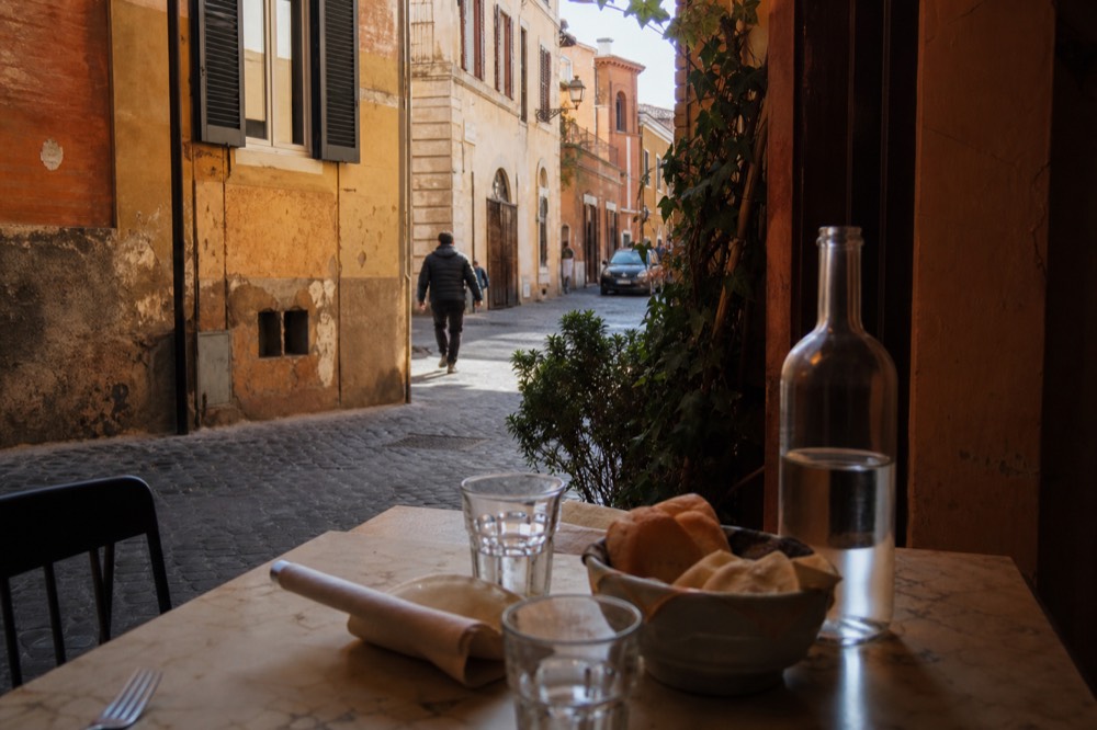 A Roman trattoria table set with bread and water