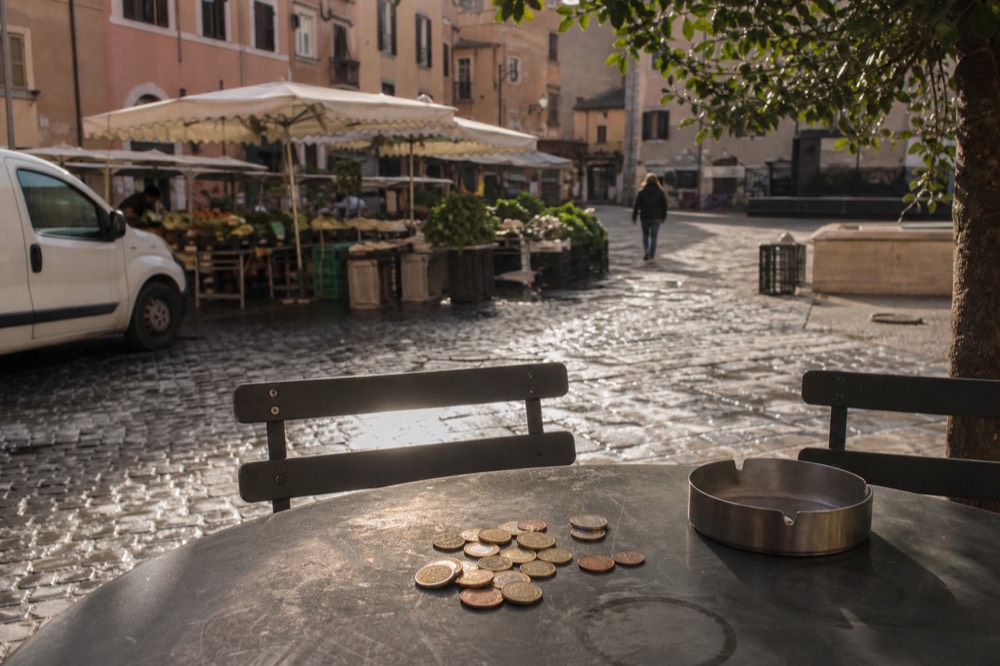 Coins resting on a cafe table in Rome