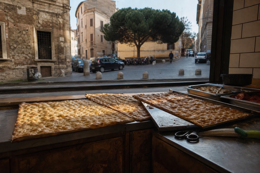 A counter of baked flatbread and trays of toppings at a Rome bakery