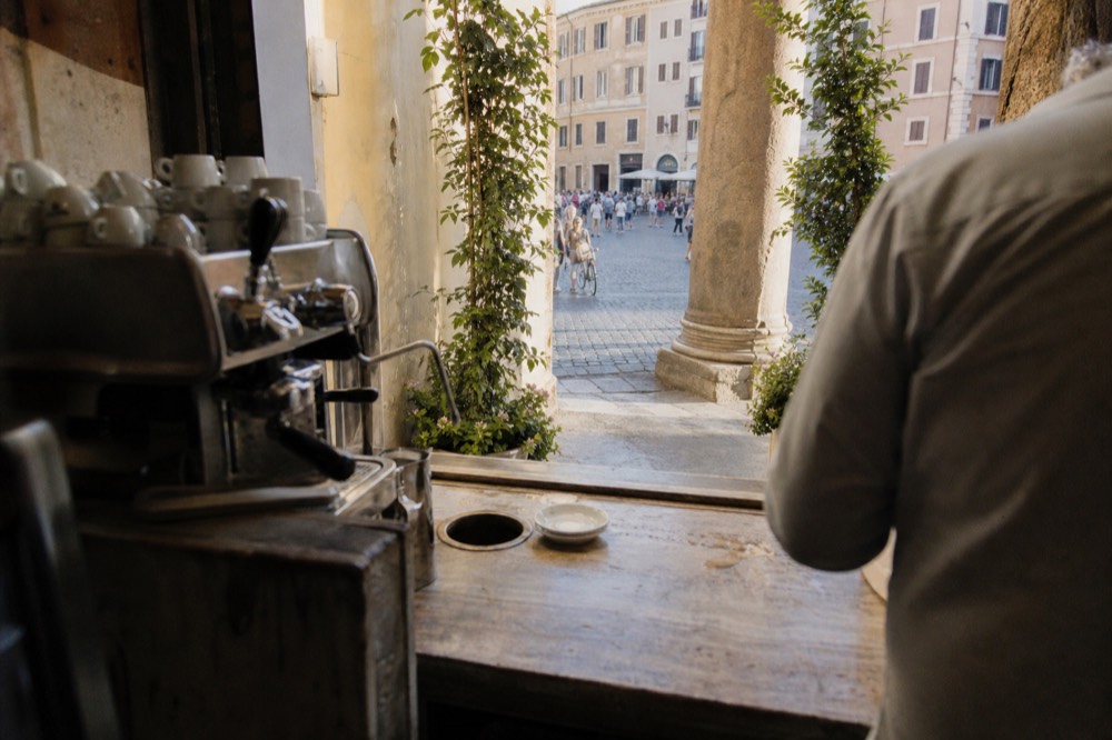 A historic Roman coffee bar interior with a standing marble counter