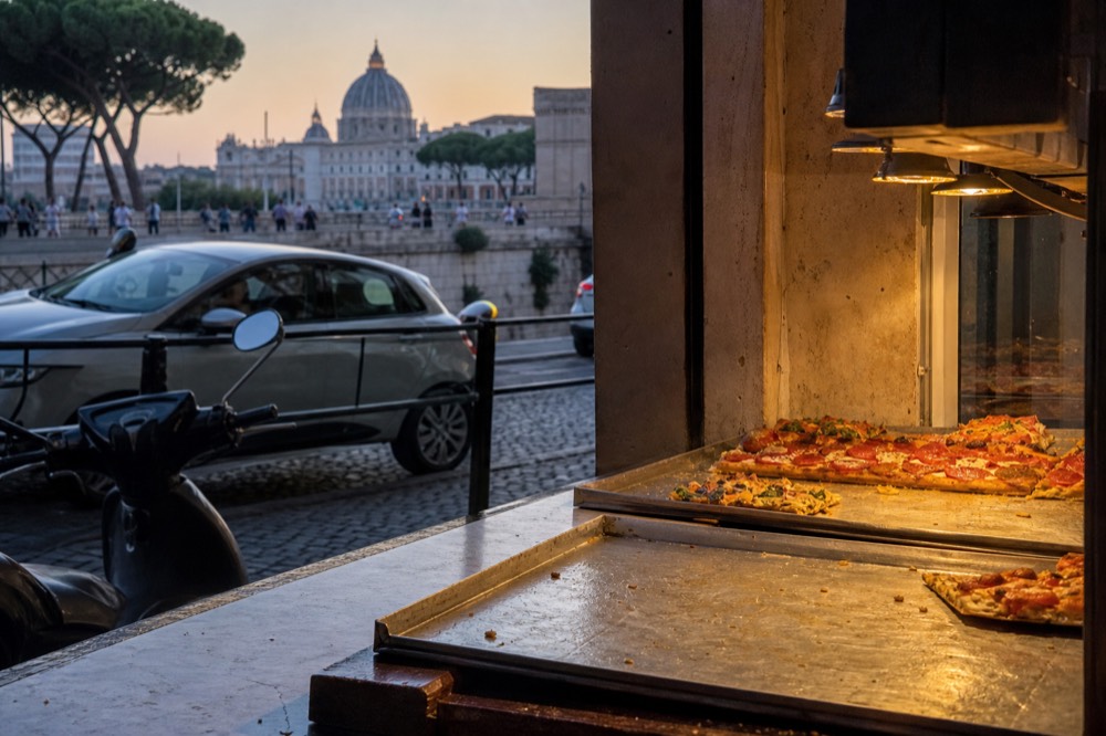 Pizza al taglio trays displayed at a counter near the Vatican