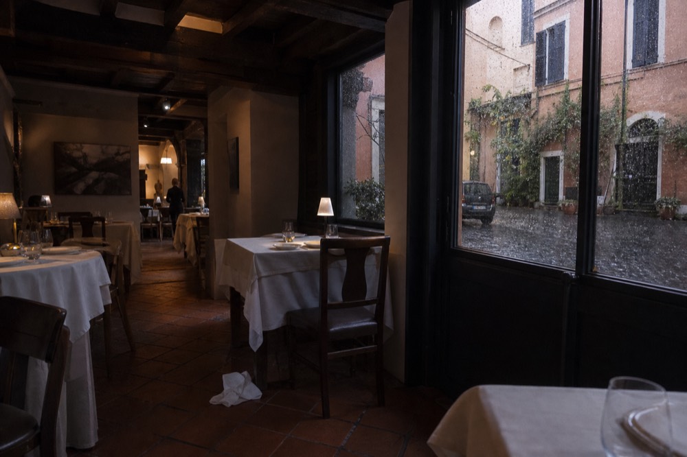 Fine dining dining room with set tables and low light