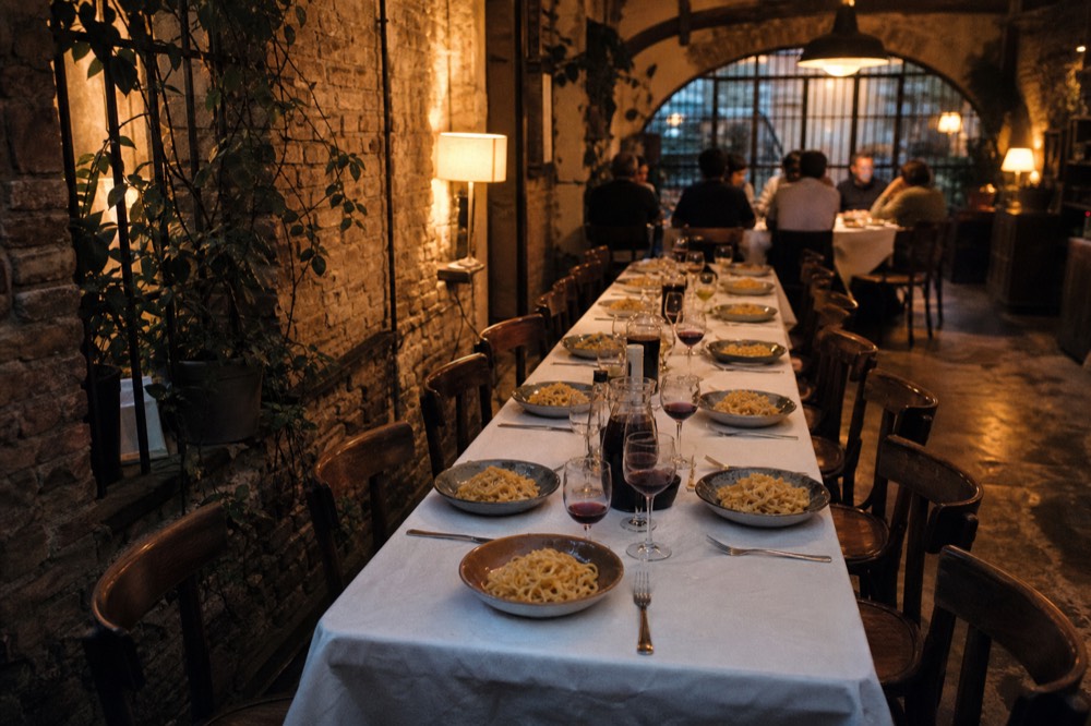 A set table with plates of fresh pasta waiting at the end of a Rome cooking class