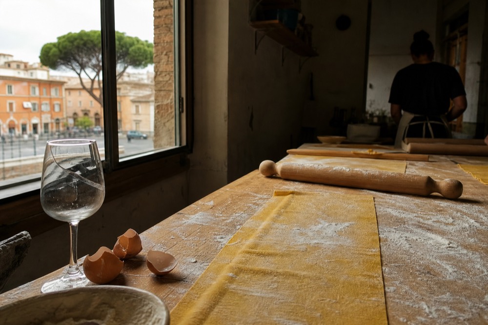 A cooking class table with fresh pasta dough and rolling pins