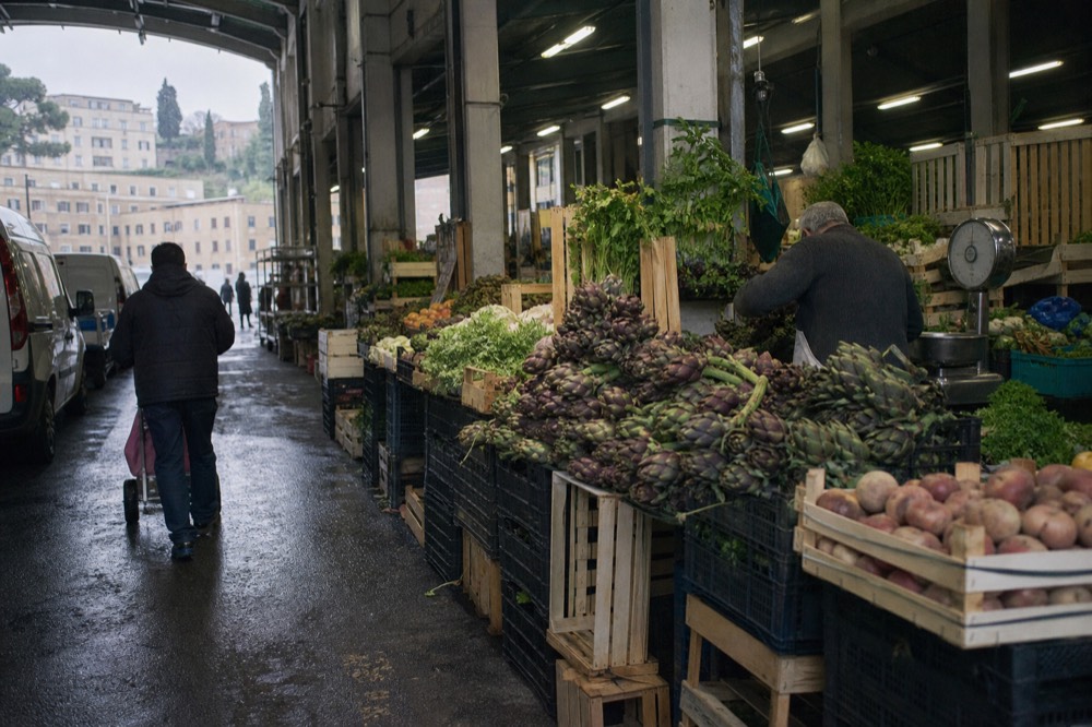 A covered Roman market aisle with produce stalls