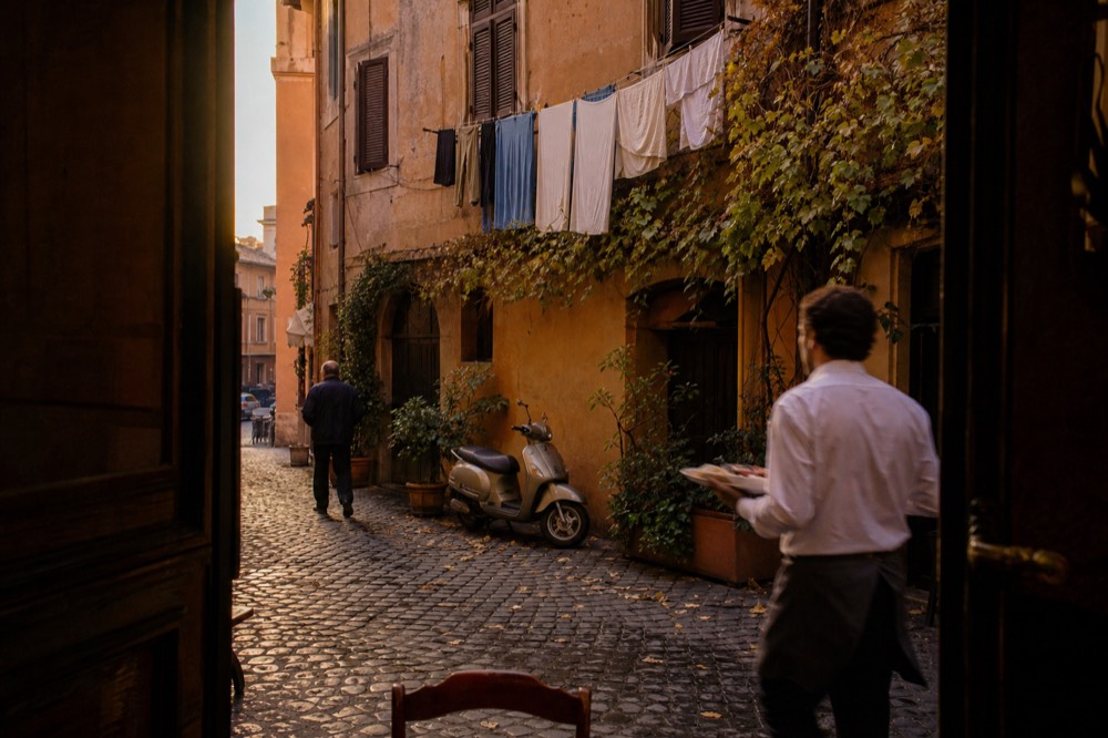 Ivy covered buildings on a cobbled Trastevere lane in warm evening light