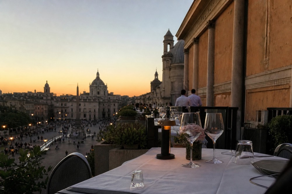 Long table on a Roman rooftop at sunset with the skyline behind