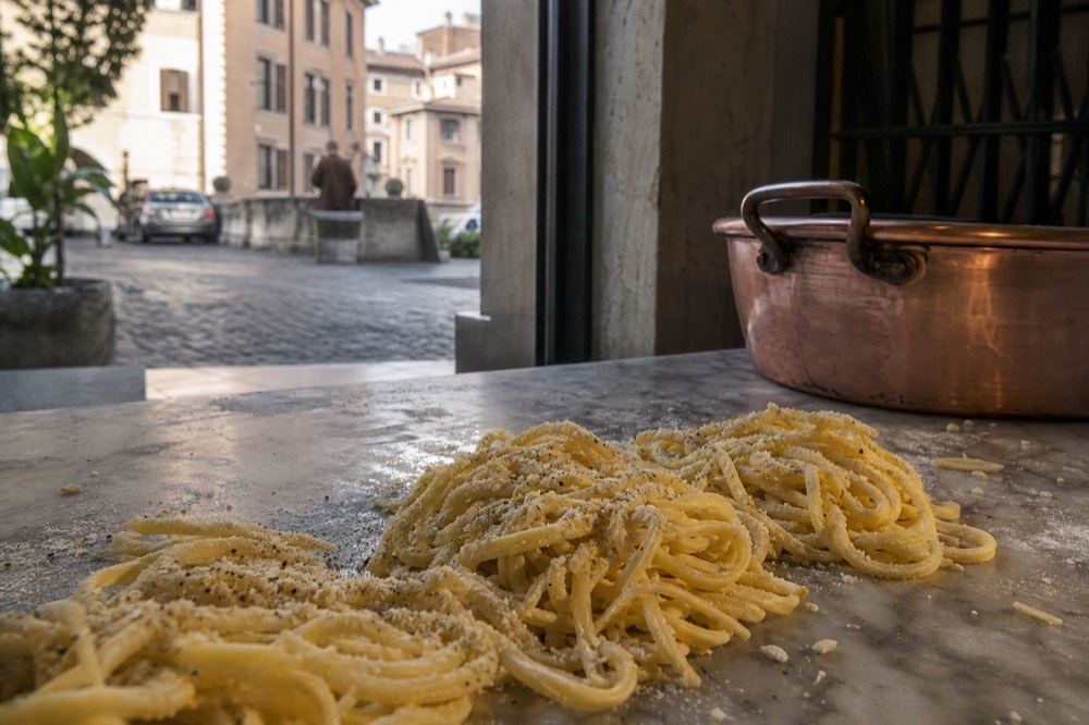 Fresh tonnarelli pasta with pecorino and cracked black pepper in a trattoria