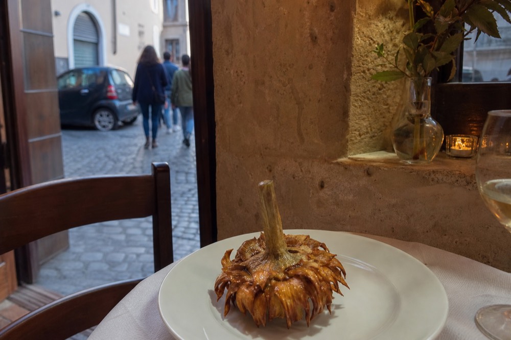 A fried Roman artichoke on a plate in a Ghetto restaurant