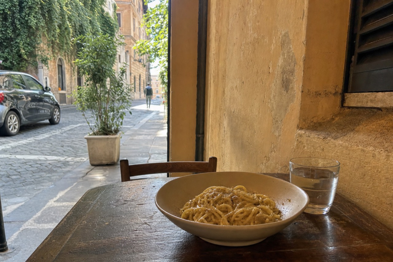 A plate of Roman pasta with pecorino and black pepper on a trattoria table
