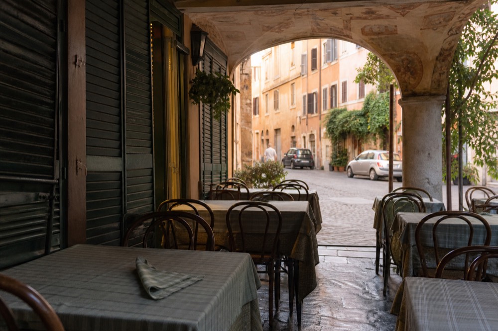 A Roman trattoria interior with wooden tables and a chalkboard menu
